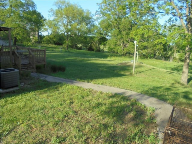 view of yard featuring cooling unit and a deck