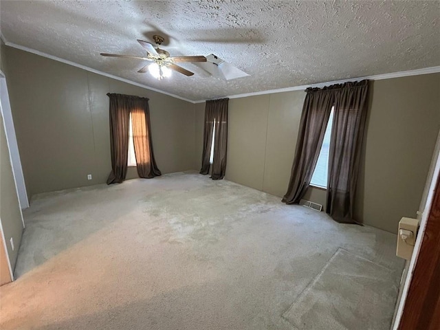 carpeted spare room with ceiling fan, crown molding, and a textured ceiling