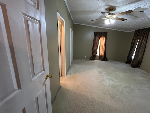 carpeted spare room featuring a textured ceiling, ceiling fan, and ornamental molding