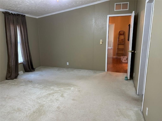 unfurnished room featuring light carpet, a textured ceiling, and ornamental molding