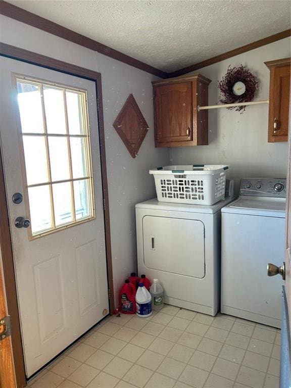 washroom featuring cabinets, a textured ceiling, crown molding, light tile patterned floors, and independent washer and dryer