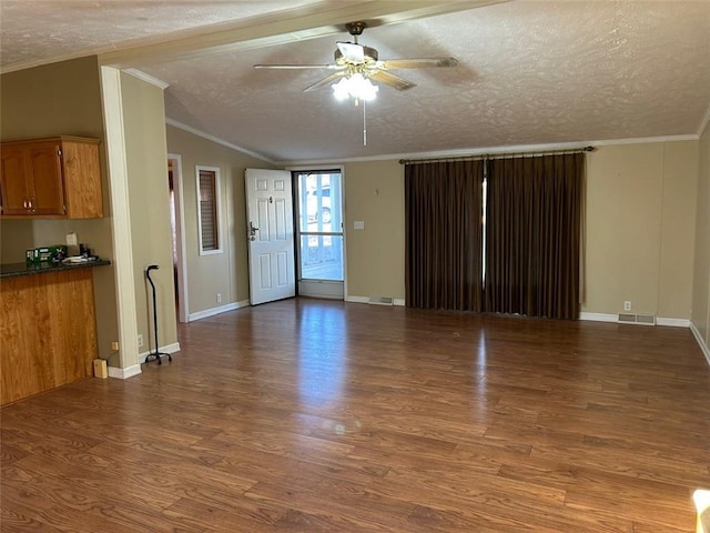 unfurnished living room featuring wood-type flooring, a textured ceiling, and ornamental molding