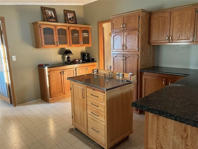 kitchen featuring a center island, light tile patterned flooring, and ornamental molding