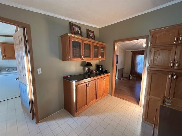 kitchen with crown molding, light wood-type flooring, and washer / dryer