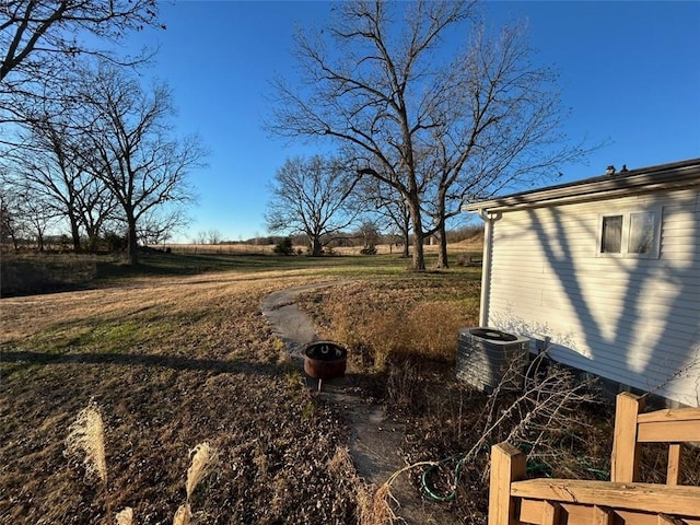 view of yard with a rural view and central AC unit