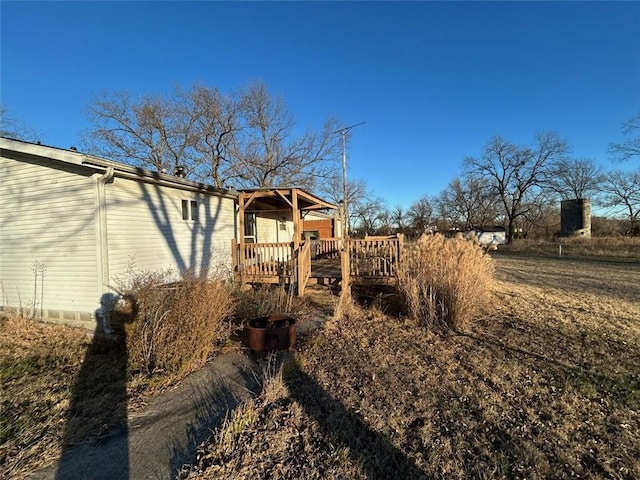 view of property exterior with a wooden deck