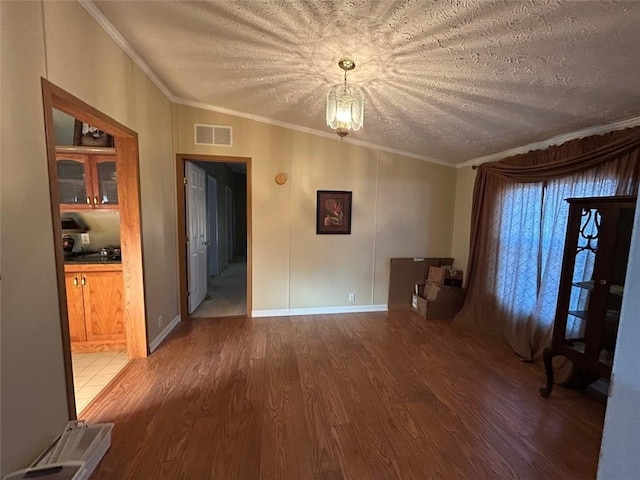 spare room featuring vaulted ceiling, dark hardwood / wood-style flooring, a textured ceiling, and ornamental molding