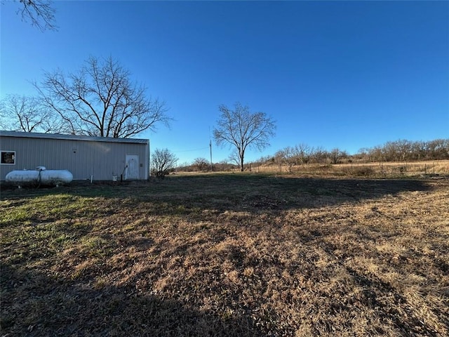 view of yard featuring a rural view and an outdoor structure