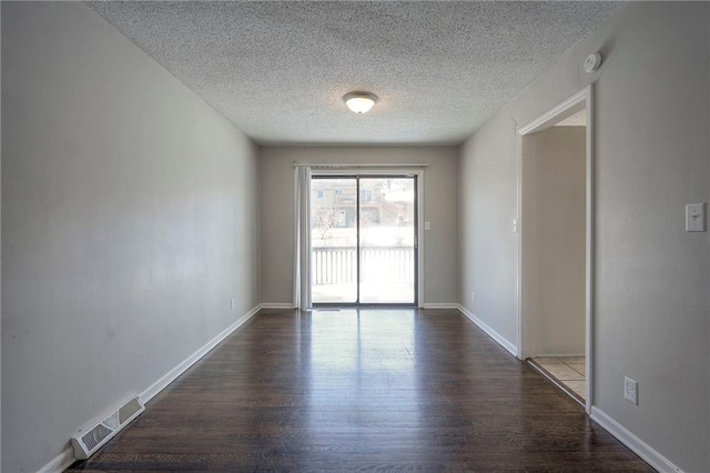 empty room featuring dark hardwood / wood-style flooring and a textured ceiling