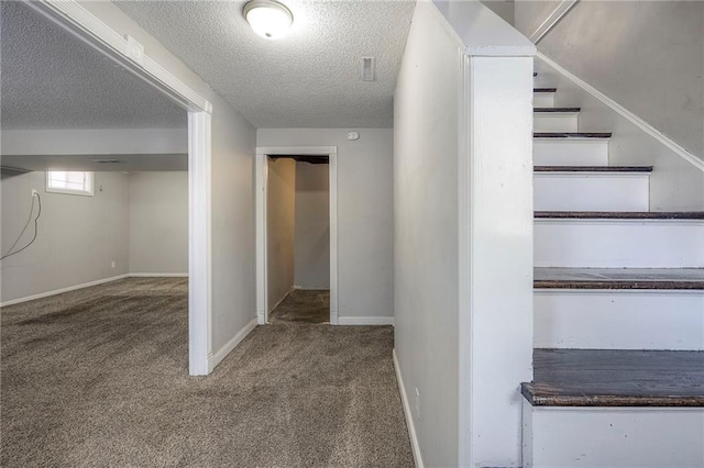 hall with carpet floors and a textured ceiling