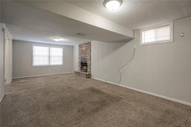 basement with a fireplace, plenty of natural light, carpet flooring, and a textured ceiling