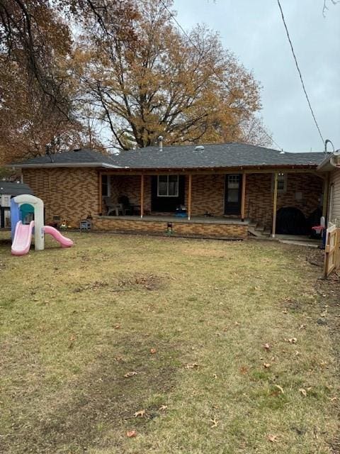 rear view of house featuring a yard, a playground, and a patio