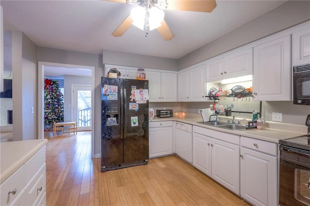 kitchen with light wood-type flooring, sink, white cabinetry, and black appliances