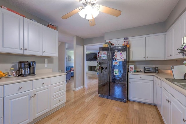 kitchen with white cabinetry, black fridge with ice dispenser, ceiling fan, and light wood-type flooring