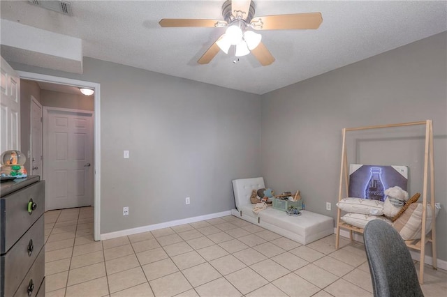 bedroom with light tile patterned floors, a textured ceiling, and ceiling fan