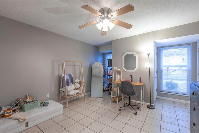 tiled home office featuring ceiling fan and a textured ceiling