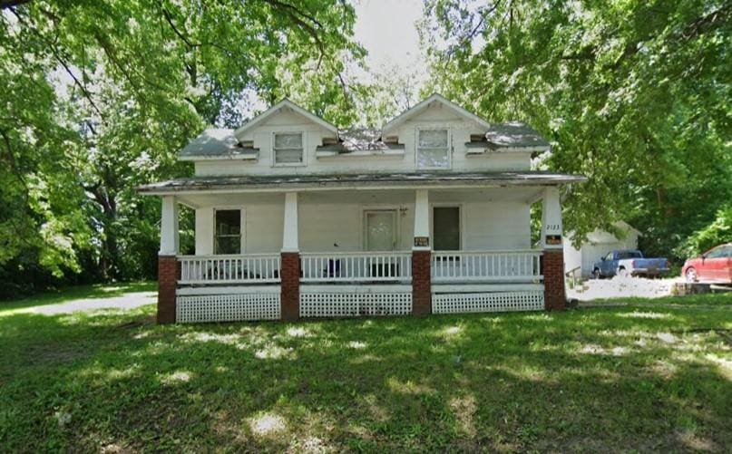 bungalow-style house with a porch and a front lawn