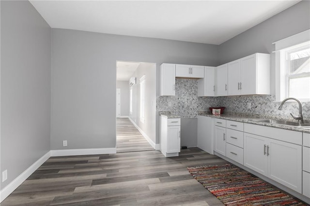 kitchen with decorative backsplash, dark hardwood / wood-style flooring, white cabinetry, and sink