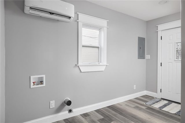 washroom featuring an AC wall unit, electric panel, hardwood / wood-style floors, and washer hookup