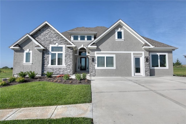 craftsman-style house with a front yard, stone siding, and stucco siding