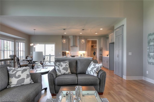 living room with an inviting chandelier and light hardwood / wood-style floors