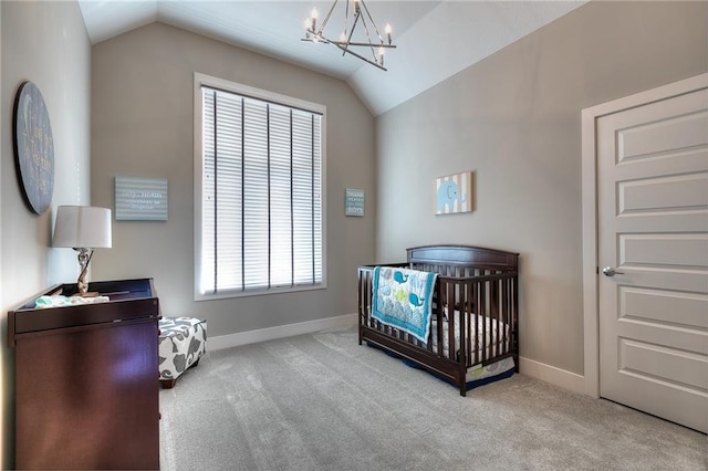 bedroom with a crib, vaulted ceiling, light carpet, and an inviting chandelier