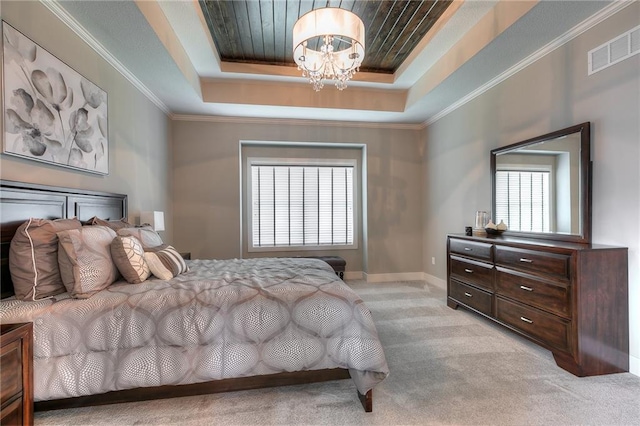 carpeted bedroom with crown molding, an inviting chandelier, and a tray ceiling