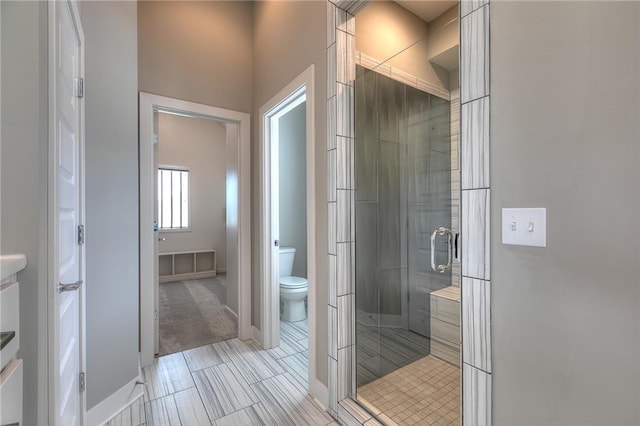 bathroom with toilet and an enclosed shower