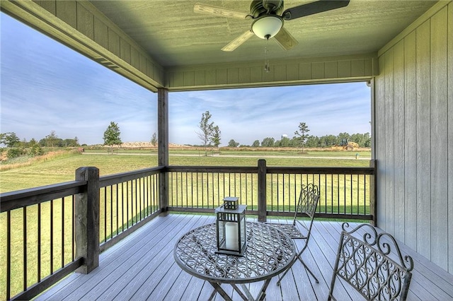 wooden terrace featuring ceiling fan and a yard