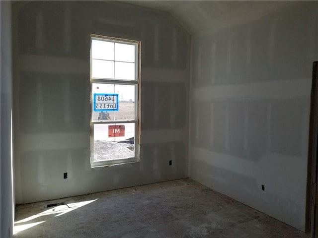 unfurnished room featuring a wealth of natural light and lofted ceiling