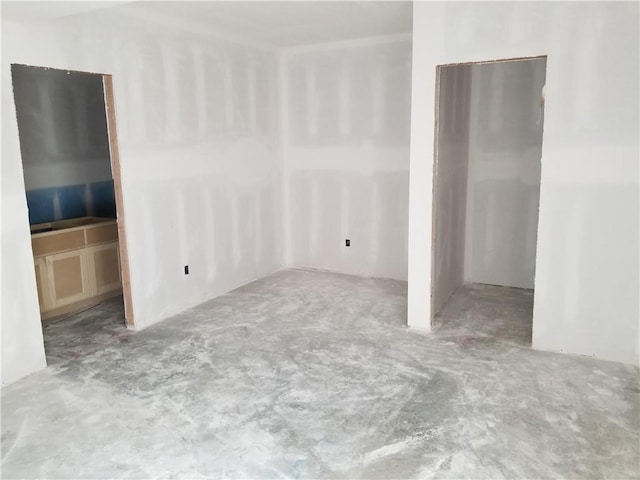 unfurnished room with unfinished concrete flooring