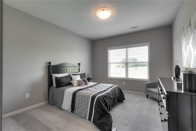 bedroom featuring light carpet, visible vents, and baseboards