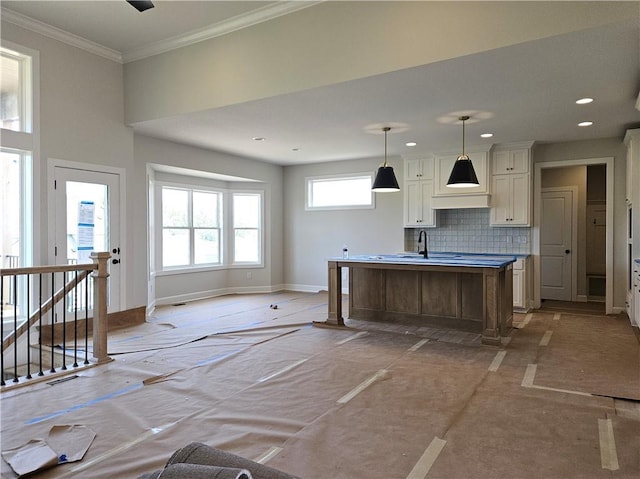 14608 Aspen Cir, Basehor, KS 66007 - kitchen with baseboards, tasteful backsplash, a kitchen island with sink, recessed lighting, and hanging light fixtures