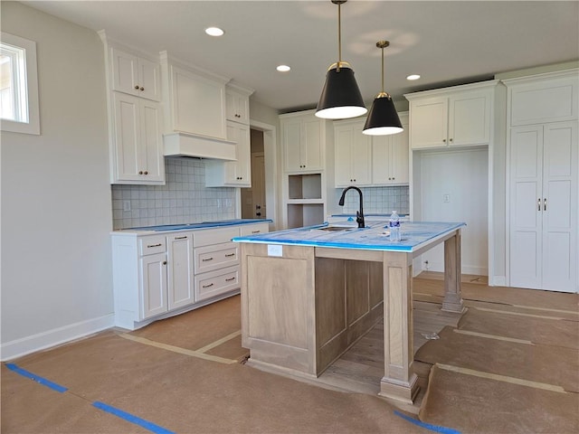 14608 Aspen Cir, Basehor, KS 66007 - kitchen with a sink, baseboards, tasteful backsplash, a center island with sink, and white cabinetry