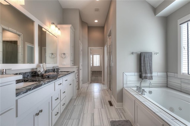 14608 Aspen Cir, Basehor, KS 66007 - bathroom featuring double vanity, a jetted tub, baseboards, a shower with shower door, and recessed lighting
