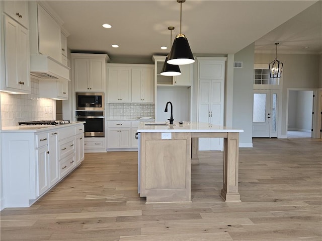 14608 Aspen Cir, Basehor, KS 66007 - kitchen with appliances with stainless steel finishes, recessed lighting, tasteful backsplash, an island with sink, and white cabinets