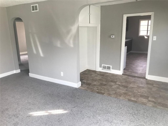 spare room featuring dark colored carpet