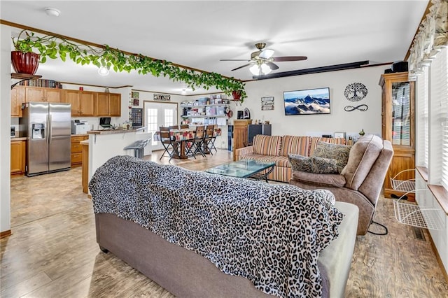 living room featuring ceiling fan, ornamental molding, french doors, and light hardwood / wood-style flooring