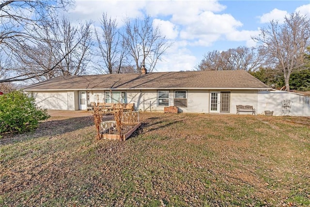 rear view of house featuring a garage and a yard