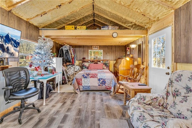 bedroom featuring wooden walls, wood-type flooring, and lofted ceiling