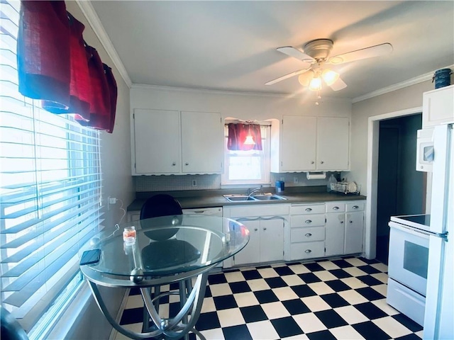 kitchen with white cabinets, white stove, and sink