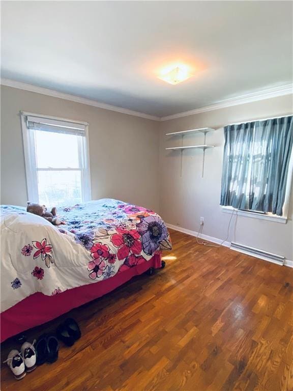 bedroom featuring baseboard heating, crown molding, and hardwood / wood-style floors