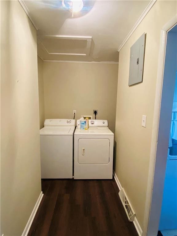 clothes washing area featuring independent washer and dryer, dark hardwood / wood-style flooring, electric panel, and crown molding