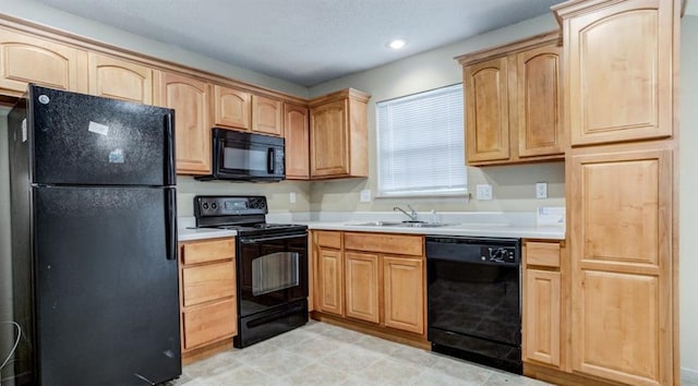 kitchen with light brown cabinets, sink, and black appliances