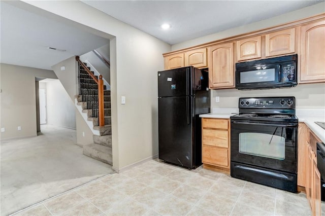 kitchen with light brown cabinets, light colored carpet, and black appliances