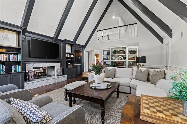 living area featuring beamed ceiling, visible vents, high vaulted ceiling, built in features, and a high end fireplace