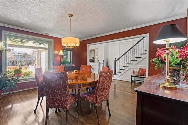 dining room with stairway, ornamental molding, a textured ceiling, and wood finished floors