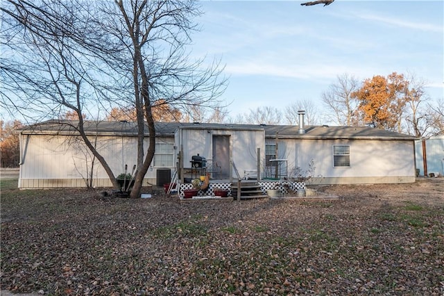 rear view of property with a deck and central air condition unit