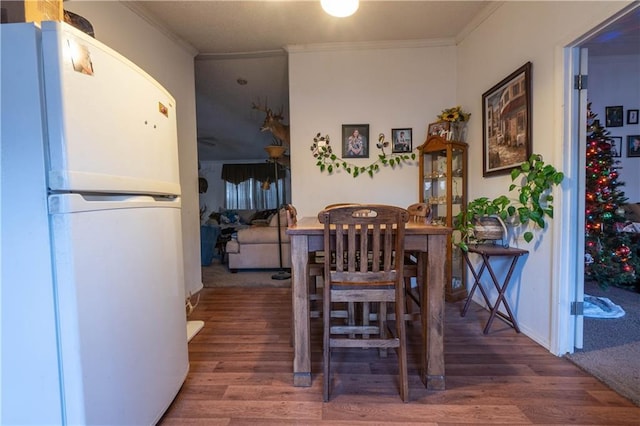 dining room with hardwood / wood-style floors and ornamental molding