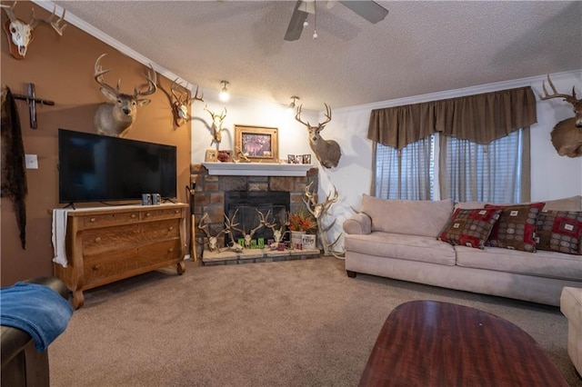 carpeted living room with ceiling fan, a fireplace, a textured ceiling, and ornamental molding